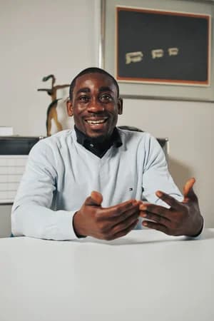 A man smiling and talking at a desk, for BD Real Estate